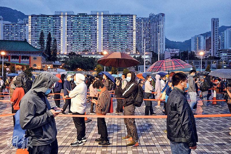 疫情蔓延至黃大仙，連日大批居民前往檢測，昨晚6時許有數百人冒雨在黃大仙廣場輪候檢測。（鄧宗弘攝）